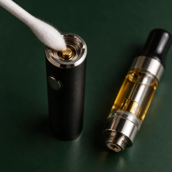 Cleaning the 510 center pin on a pen battery with a cotton swab